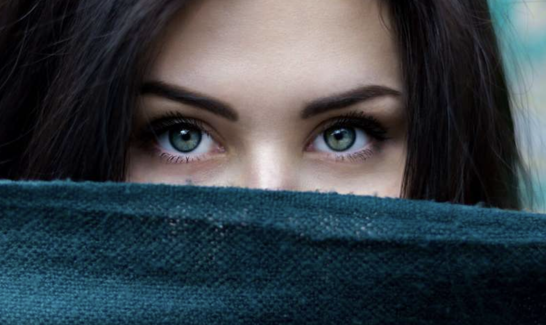 photo of a woman's eyes staring forward behind cloth covering her face