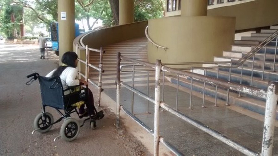 photo of woman in wheelchair facing difficulty going up stairs