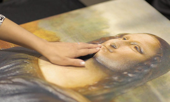 woman's hand touching a relief photo of the mona lisa