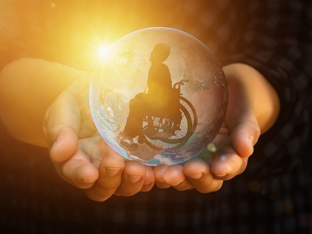 photo of hands holding a globe with photo of wheelchair user inside