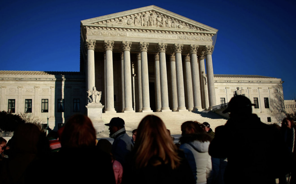 Photo of people standing in the steps of the supreme court