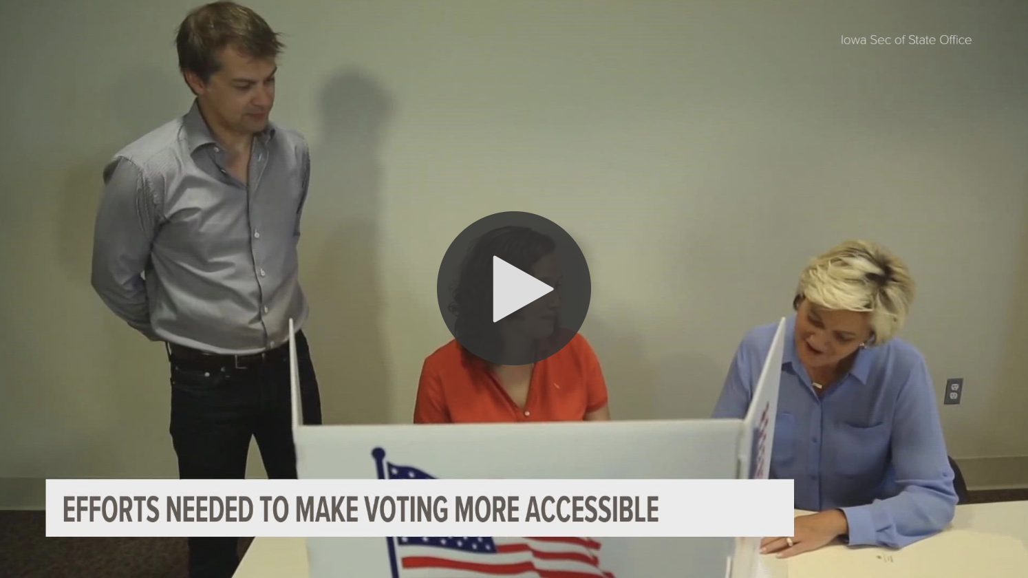 screenshot of video clip - voters around a table