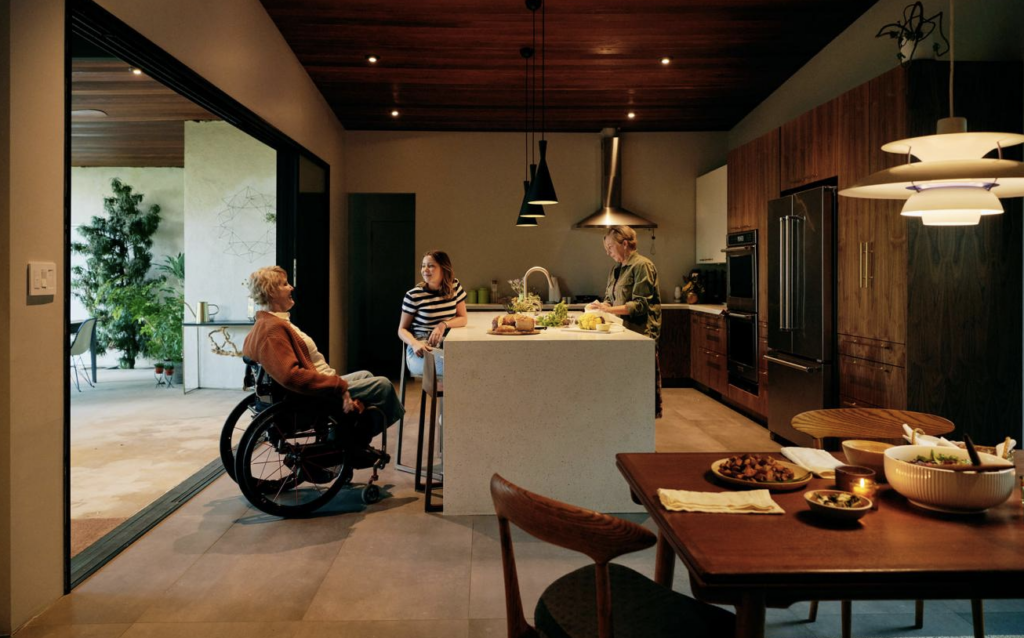 Person in wheelchair with others in kitchen