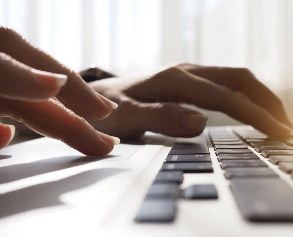 photo of two hands using a laptop keyboard