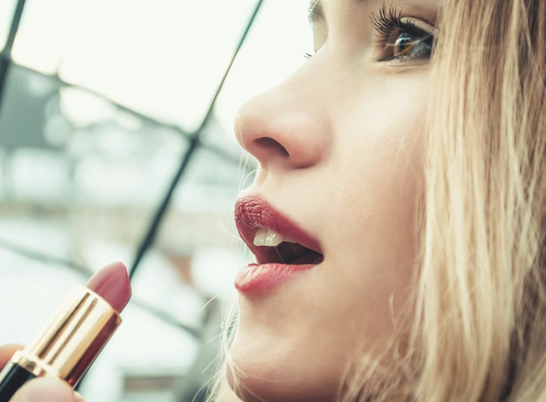photo of woman applying makeup