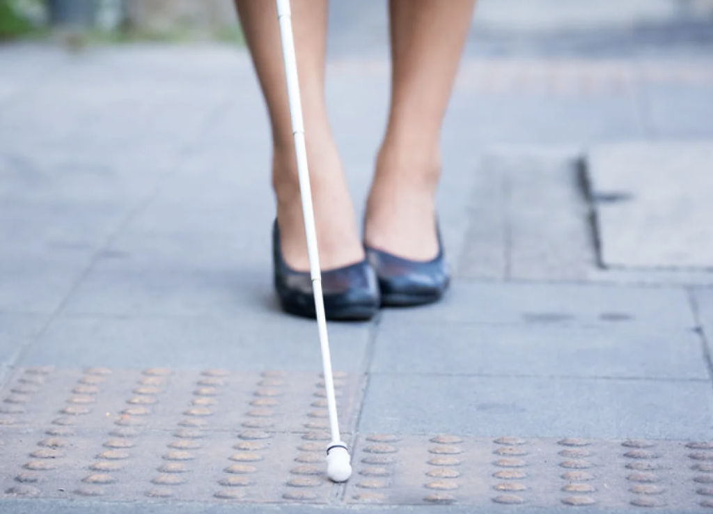 photo of person walking with white cane