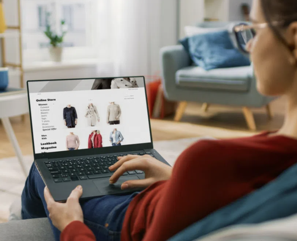 photo of person sitting on couch shopping online via laptop